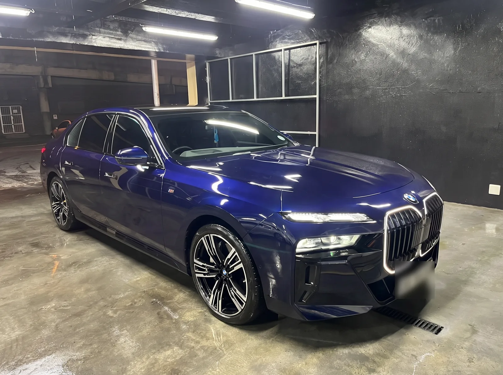 A dark blue BMW 740Li sedan, front view